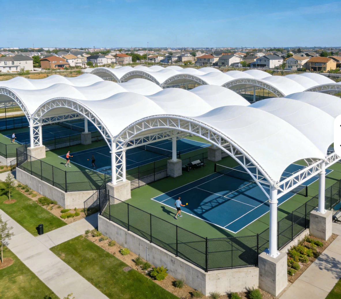 Aerial view of tennis courts covered by white tensile membrane roofs